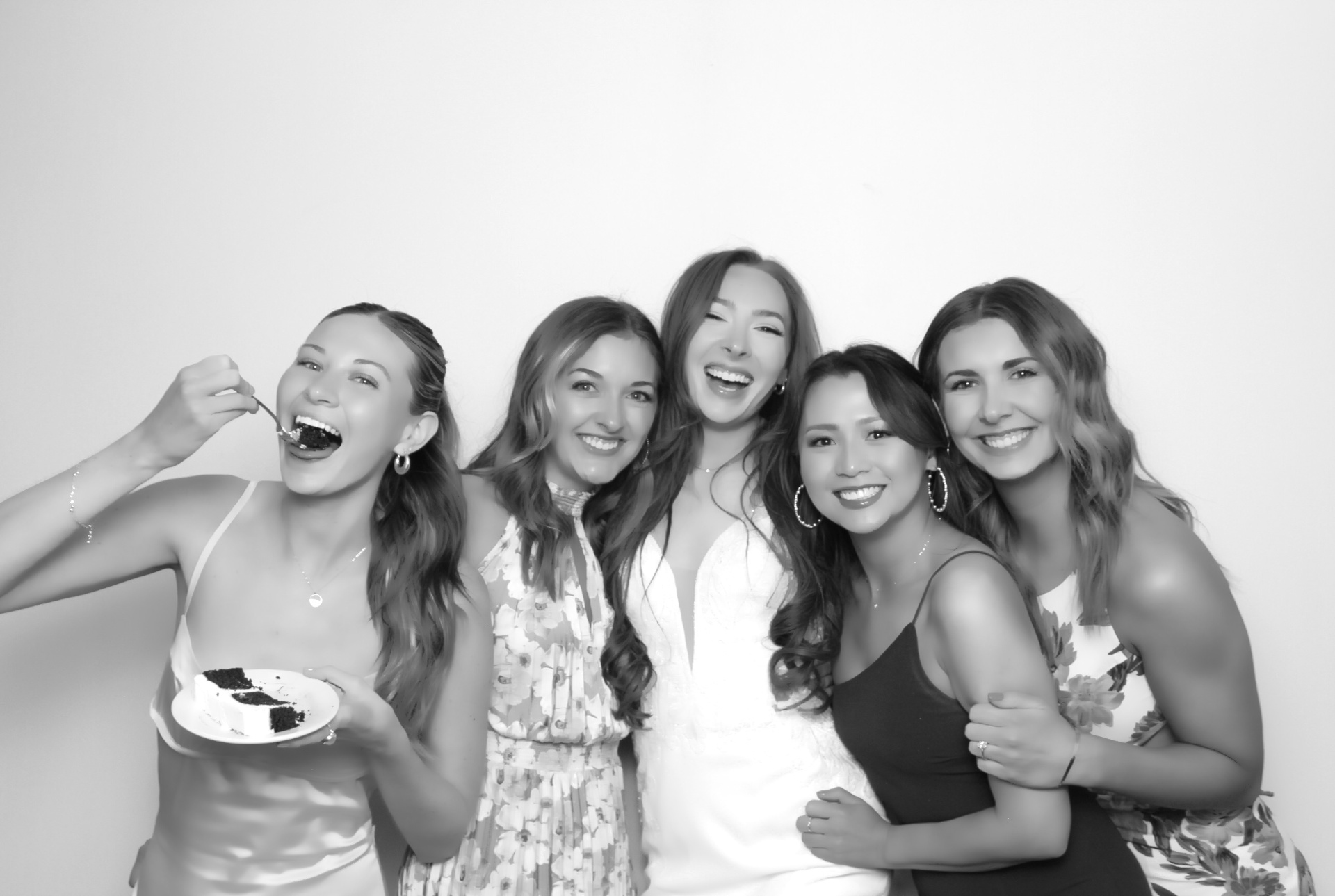 Bridesmaids and bride laughing together in an elegant black-and-white wedding photo