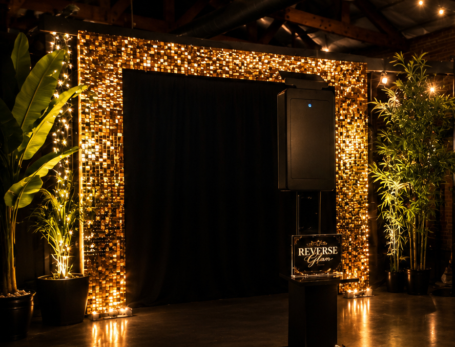 Reverse glam shimmer wall photo booth with candlelit greenery