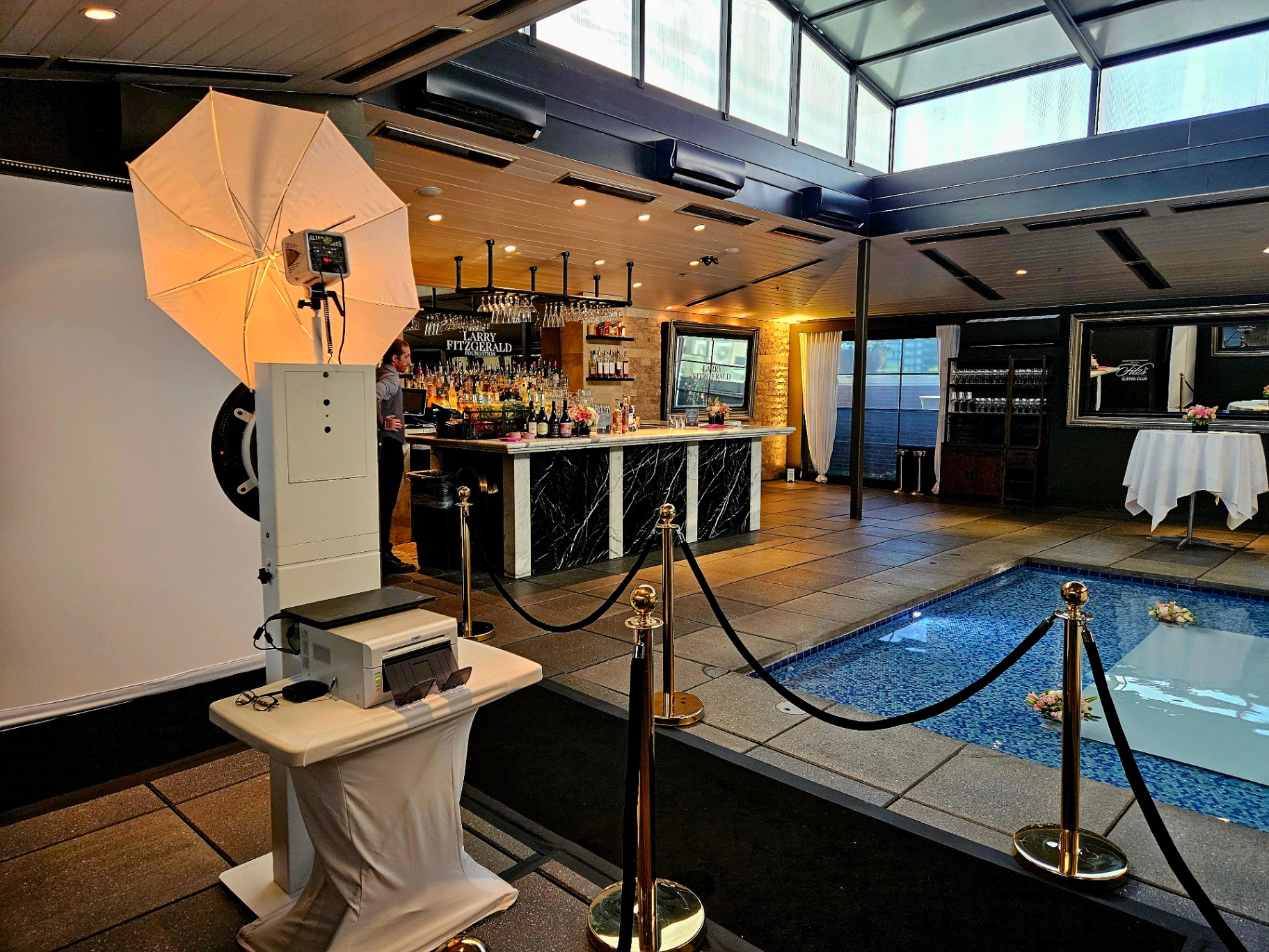 Elegant VIP arrival experience with stanchions, professional lighting, and a polished photo booth presentation