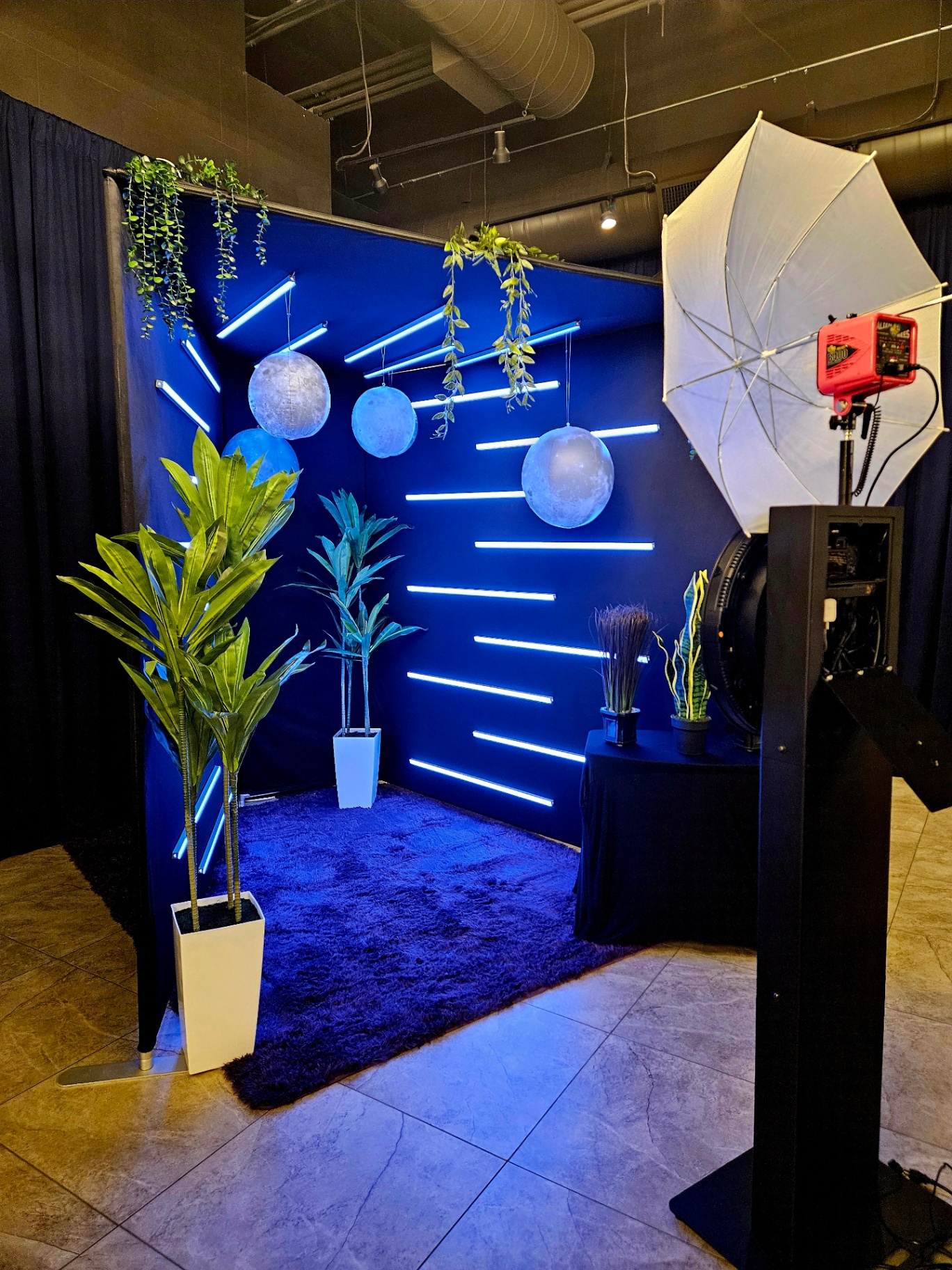 Vogue booth with neon-lit blue backdrop and hanging moons