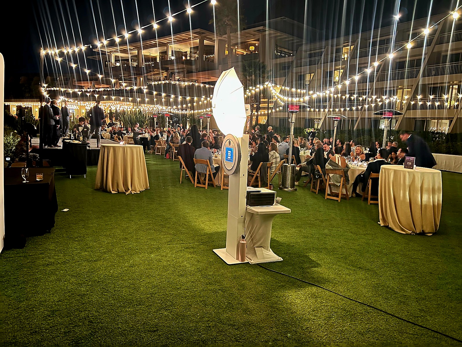 Outdoor gala with string lights and photo booth setup